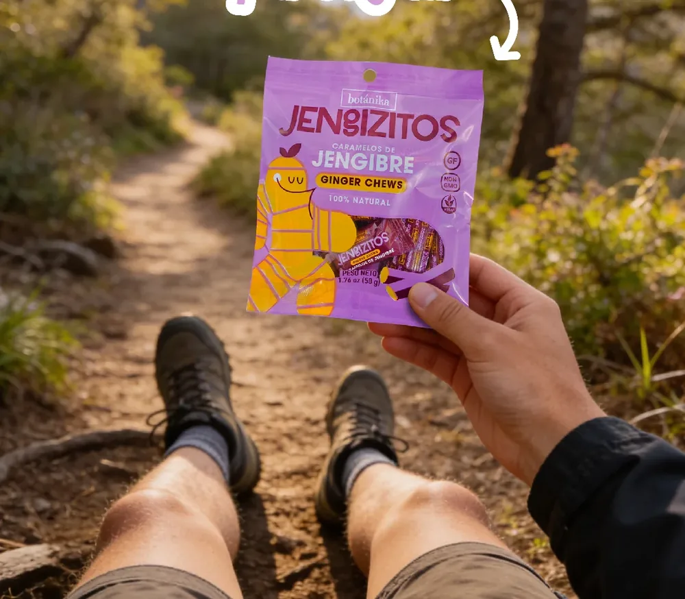 Una mano sostiene una bolsa de caramelos Jengizitos en un sendero de montaña