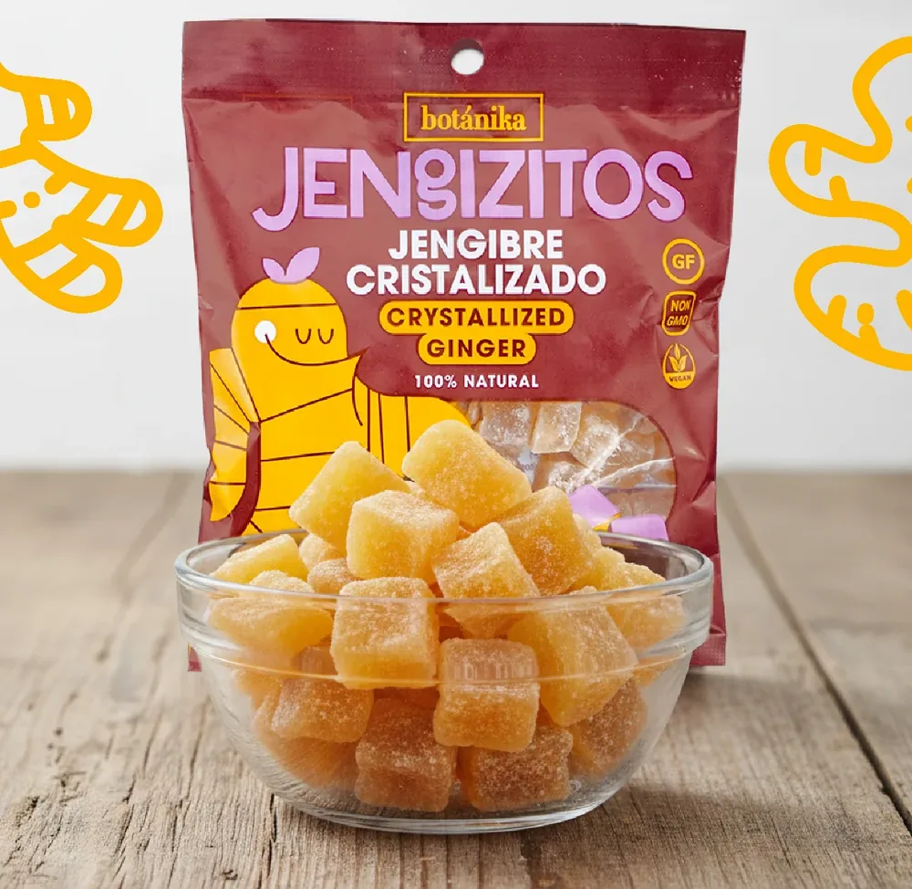 Bolsa de jengibre cristalizado junto a un bol de vidrio lleno de cubitos azucarados